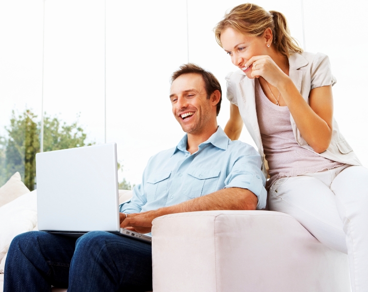 Happy mature man and woman using a computer laptop